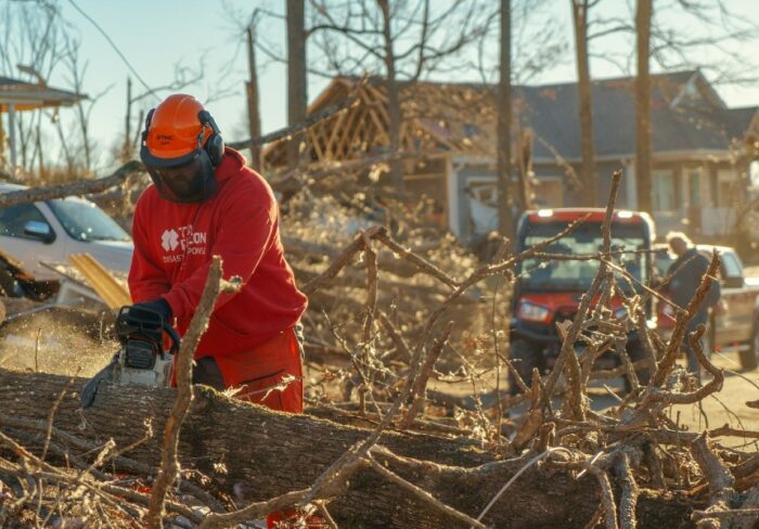 Team Rubicon volunteer chainsawing a fallen tree